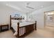 Bedroom with wooden bed frame, ceiling fan, view of ensuite bathroom and natural light at 106 N Blvd Of The Presidents, Sarasota, FL 34236