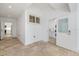 Open hallway view with travertine floors leading to the kitchen and laundry room at 106 N Blvd Of The Presidents, Sarasota, FL 34236