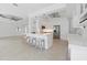 Open-concept kitchen featuring stainless appliances, a center island with seating, and an elegant ceiling fan at 106 N Blvd Of The Presidents, Sarasota, FL 34236