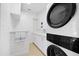 Modern laundry room features stacked washer and dryer and ample storage at 106 N Blvd Of The Presidents, Sarasota, FL 34236