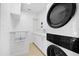 Modern laundry room featuring a stacked washer and dryer with white cabinets and ample counter space at 106 N Blvd Of The Presidents, Sarasota, FL 34236