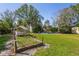Expansive backyard featuring lush green grass, mature trees, and a charming seating area, perfect for outdoor relaxation at 109 Burney Rd, Osprey, FL 34229