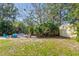 Expansive backyard showcases lush greenery, patio, firepit, and a storage shed for outdoor enjoyment at 109 Burney Rd, Osprey, FL 34229