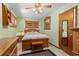 Cozy bedroom with a ceiling fan, light green walls, wooden furniture, and a comfortable queen-sized bed at 109 Burney Rd, Osprey, FL 34229