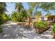 Charming exterior view features a gravel driveway, lush landscaping, and inviting facade with a glimpse of a relaxing hot tub at 109 Burney Rd, Osprey, FL 34229
