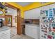 Kitchen featuring white cabinets, neutral counters, and yellow walls. Adjacent to sunroom at 109 Burney Rd, Osprey, FL 34229