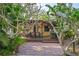 Inviting outdoor deck with a dining area, grill, and string lights, ideal for entertaining amidst tropical foliage at 109 Burney Rd, Osprey, FL 34229