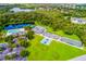 Aerial view showcasing community amenities: pool, tennis courts, playground, and lush landscaping, offering diverse activities at 11739 River Shores Trl, Parrish, FL 34219