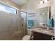 Modern bathroom with a glass enclosed shower, granite countertop, and decorative fish art at 11739 River Shores Trl, Parrish, FL 34219