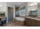 Elegant bathroom featuring a soaking tub, a glass-enclosed shower, and dual vanities, creating a spa-like experience at 11739 River Shores Trl, Parrish, FL 34219