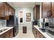 Modern kitchenette with dark wood cabinets, stainless steel appliances, and stylish backsplash, maximizing convenience at 11739 River Shores Trl, Parrish, FL 34219