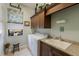 Well-lit laundry room with granite countertops, a sink, and window overlooking the backyard at 11739 River Shores Trl, Parrish, FL 34219