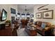 Cozy living room with a leather sofa, bar area, and arched windows, perfect for relaxing and entertaining guests at 11739 River Shores Trl, Parrish, FL 34219