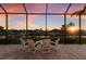 Relaxing screened-in patio with comfortable seating and a beautiful waterfront view at sunset at 11739 River Shores Trl, Parrish, FL 34219
