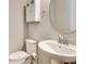 Bright bathroom featuring a pedestal sink, white cabinets, and a modern, round mirror at 11831 Brookside Dr, Bradenton, FL 34211