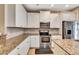 Modern kitchen featuring stainless steel appliances, granite countertops, and custom white cabinets at 11831 Brookside Dr, Bradenton, FL 34211