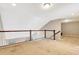 An unfinished loft space featuring neutral paint, natural light, and dark-stained wood railings at 11831 Brookside Dr, Bradenton, FL 34211