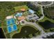 An aerial view captures the community's array of sports facilities and winding roads surrounded by lush landscaping and ponds at 12022 Granite Woods Loop, Venice, FL 34292