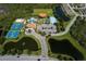 An aerial view showcasing community amenities including tennis and basketball courts, pools, and scenic waterways at 12022 Granite Woods Loop, Venice, FL 34292