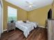 Bedroom with two twin beds, wood floors, ceiling fan, and natural light from the window at 12022 Granite Woods Loop, Venice, FL 34292