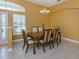 Elegant dining area featuring tile floors, pendant lighting, and a view of the lush backyard at 12022 Granite Woods Loop, Venice, FL 34292