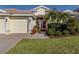 Charming single-story home with a three-car garage, an arched entryway, and a well-manicured lawn at 12022 Granite Woods Loop, Venice, FL 34292