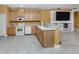 Bright kitchen with modern appliances and breakfast bar overlooking the living room and fireplace at 12022 Granite Woods Loop, Venice, FL 34292
