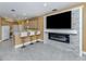 Kitchen breakfast bar facing an integrated living space featuring a stone fireplace and large TV at 12022 Granite Woods Loop, Venice, FL 34292