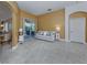 Bright living room featuring neutral decor, tile flooring, and sliding glass doors offering backyard views at 12022 Granite Woods Loop, Venice, FL 34292