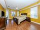 Large main bedroom suite with hardwood floors, a ceiling fan, and natural light from multiple windows at 12022 Granite Woods Loop, Venice, FL 34292
