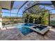 Pool, spa and enclosure with a view of the lake and landscaping at 12022 Granite Woods Loop, Venice, FL 34292