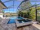 Screened pool area with a pool, spa, and view of the lake at 12022 Granite Woods Loop, Venice, FL 34292