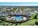 An aerial view showcasing the community clubhouse with pool, tennis courts, bocce ball, and ponds at 12448 Golden Sage Dr, Sarasota, FL 34238