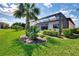 Lush backyard featuring a screened-in lanai with a pool and spa, surrounded by tropical landscaping and privacy hedges at 12448 Golden Sage Dr, Sarasota, FL 34238