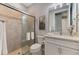 Bathroom showcasing a tiled shower with glass door, vanity with white cabinet and mirror at 12448 Golden Sage Dr, Sarasota, FL 34238