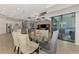 Open dining area with glass table, modern lighting, and view of the kitchen and living room at 12448 Golden Sage Dr, Sarasota, FL 34238