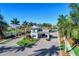Community entrance gate surrounded by manicured landscaping and palm trees under a clear blue sky at 12448 Golden Sage Dr, Sarasota, FL 34238