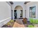 Inviting front porch with brick pathway leading to a glass-paned door surrounded by well-kept landscaping at 12448 Golden Sage Dr, Sarasota, FL 34238