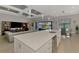 Well-lit open-concept kitchen with a large kitchen island that overlooks the living room and outdoor pool area at 12448 Golden Sage Dr, Sarasota, FL 34238