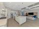 Open kitchen with stainless appliances, white cabinets, large island, and open floor plan at 12448 Golden Sage Dr, Sarasota, FL 34238