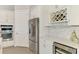Well-lit kitchen with stainless steel appliances, wine rack, and elegant white cabinetry at 12448 Golden Sage Dr, Sarasota, FL 34238