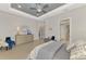 Spacious main bedroom showcasing a tray ceiling, stylish furniture, and an adjoining ensuite bathroom at 12448 Golden Sage Dr, Sarasota, FL 34238