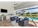 Outdoor kitchen with a grill, seating area, and view of the pool and lush landscaping at 12448 Golden Sage Dr, Sarasota, FL 34238