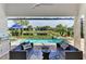 Inviting covered patio with a stunning pool, hot tub, and serene water view for luxurious outdoor living and entertaining at 12448 Golden Sage Dr, Sarasota, FL 34238