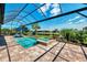 Gorgeous screened-in pool and spa overlooking a tranquil pond with lush landscaping and ample space for relaxation at 12448 Golden Sage Dr, Sarasota, FL 34238