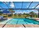 Enjoy the view from this pristine screened-in pool and spa with a beautiful pond and manicured landscaping at 12448 Golden Sage Dr, Sarasota, FL 34238