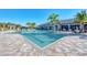 Resort style pool with palm trees and many lounge chairs and tables with umbrellas on a bright sunny day at 12448 Golden Sage Dr, Sarasota, FL 34238