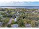 Aerial view of a home nestled in a wooded neighborhood with water views in the distance at 1302 5Th W St, Palmetto, FL 34221