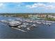 Low aerial view of marina with many boats docked and building at the end of pier beneath a cloudy, blue sky at 1302 5Th W St, Palmetto, FL 34221