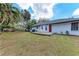 Backyard with a wooden deck, shed, and mature trees under a blue sky at 1302 5Th W St, Palmetto, FL 34221